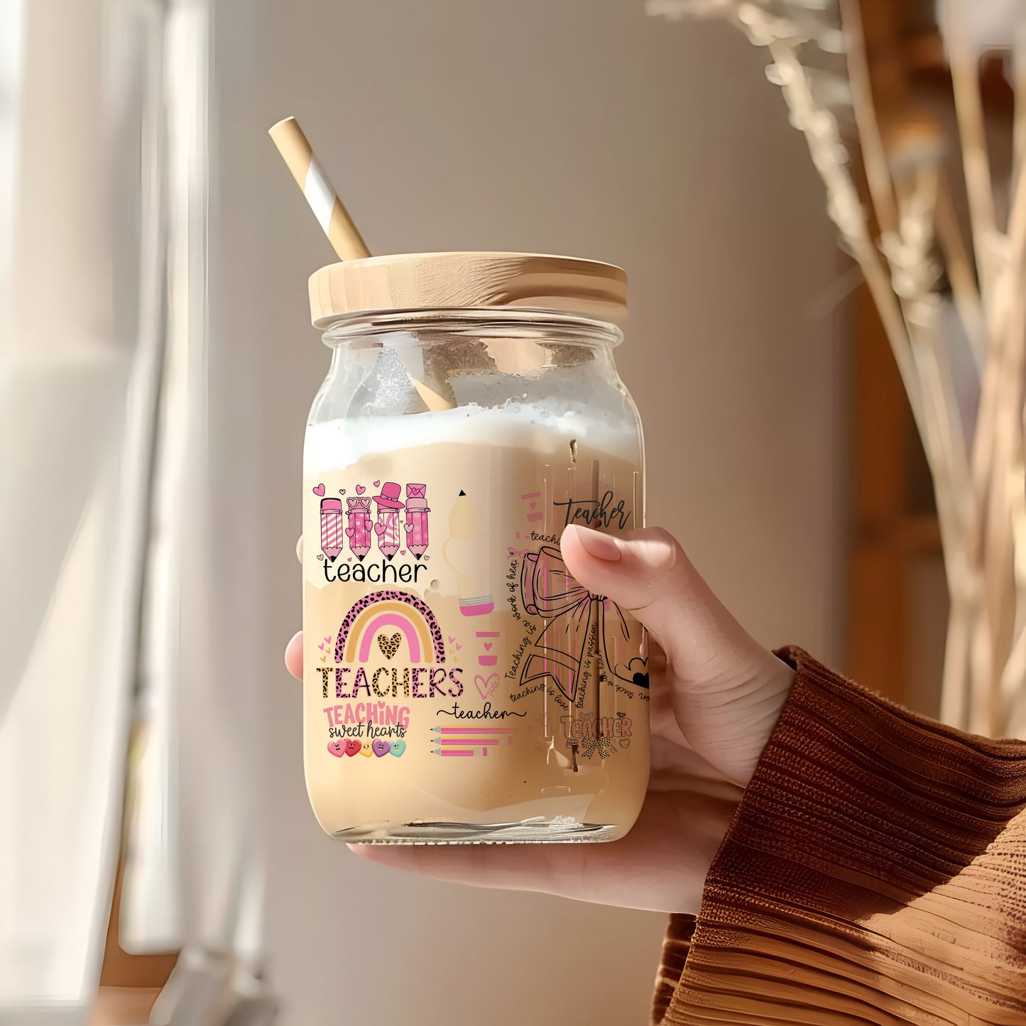 a person holding a glass jar with a straw in it