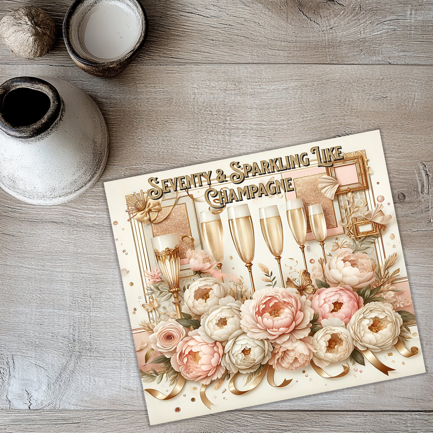 a card with a floral design and champagne glasses, placed on a wooden surface.