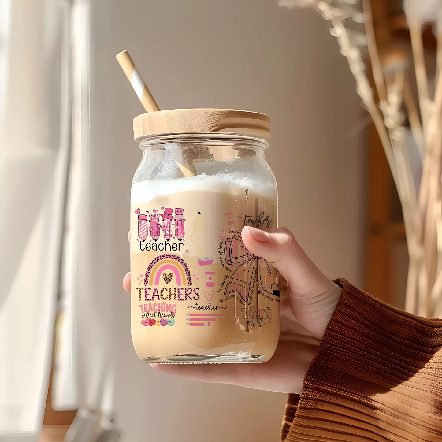 a person holding a glass jar with a straw in it