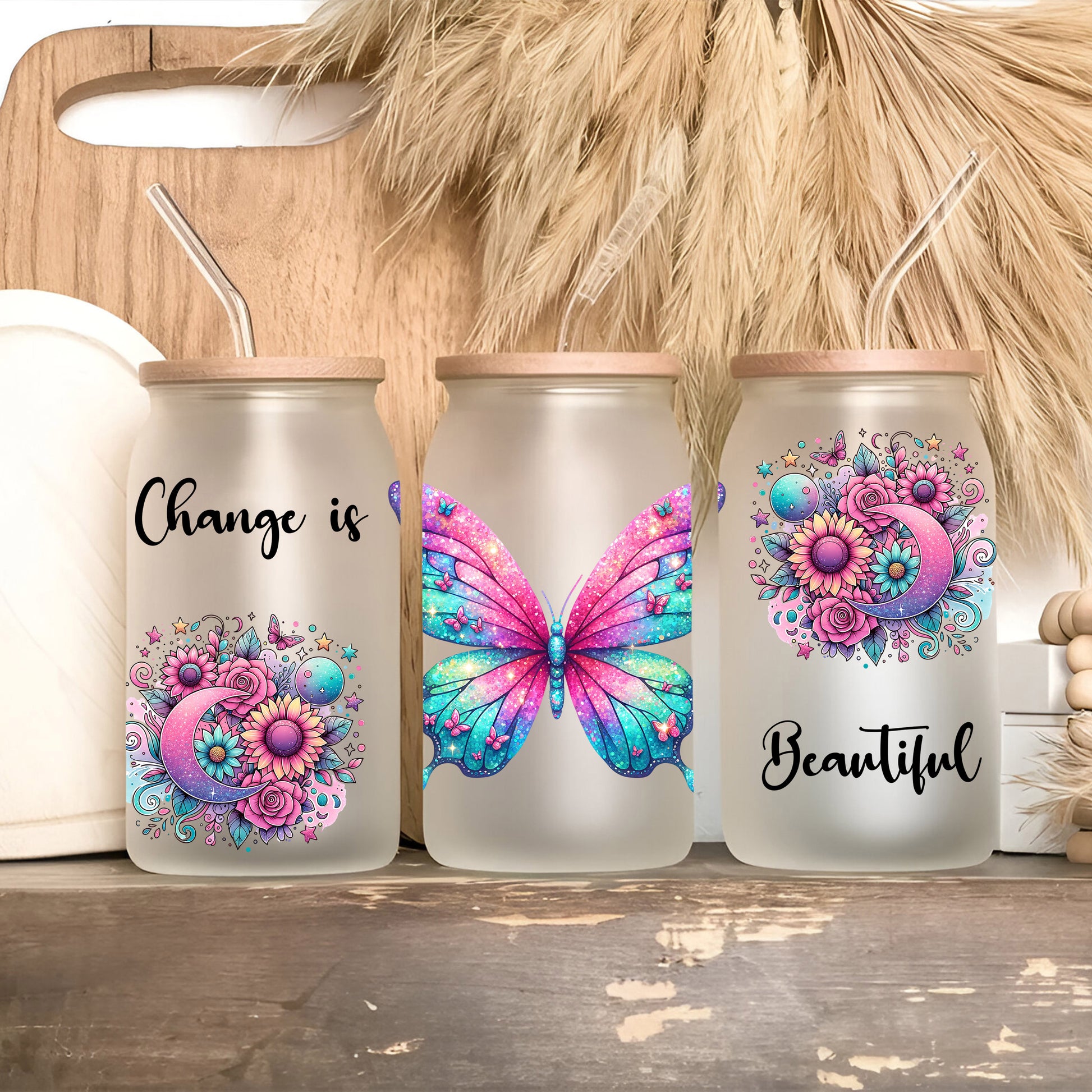 a group of three glass jars with butterflies painted on them