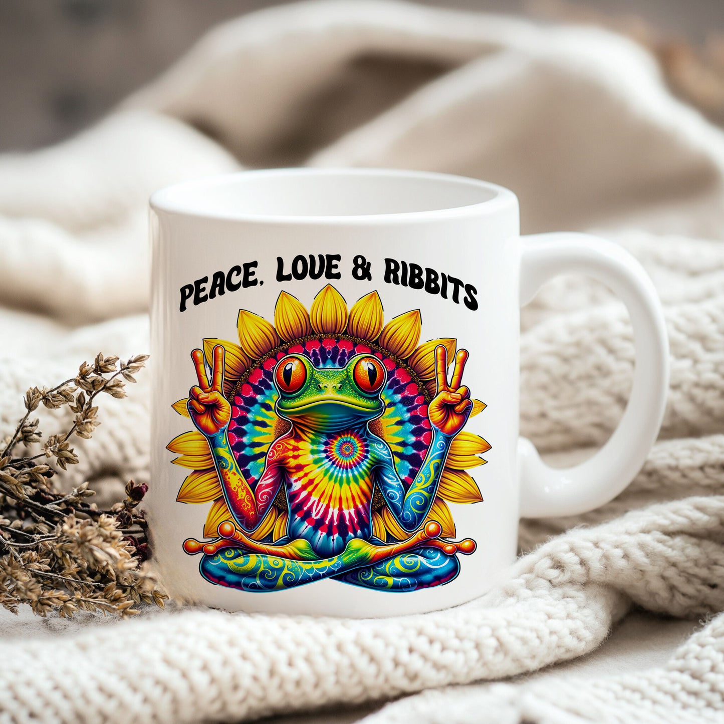 A white mug with a colorful illustration of a frog holding a peace sign, surrounded by a sunflower design.