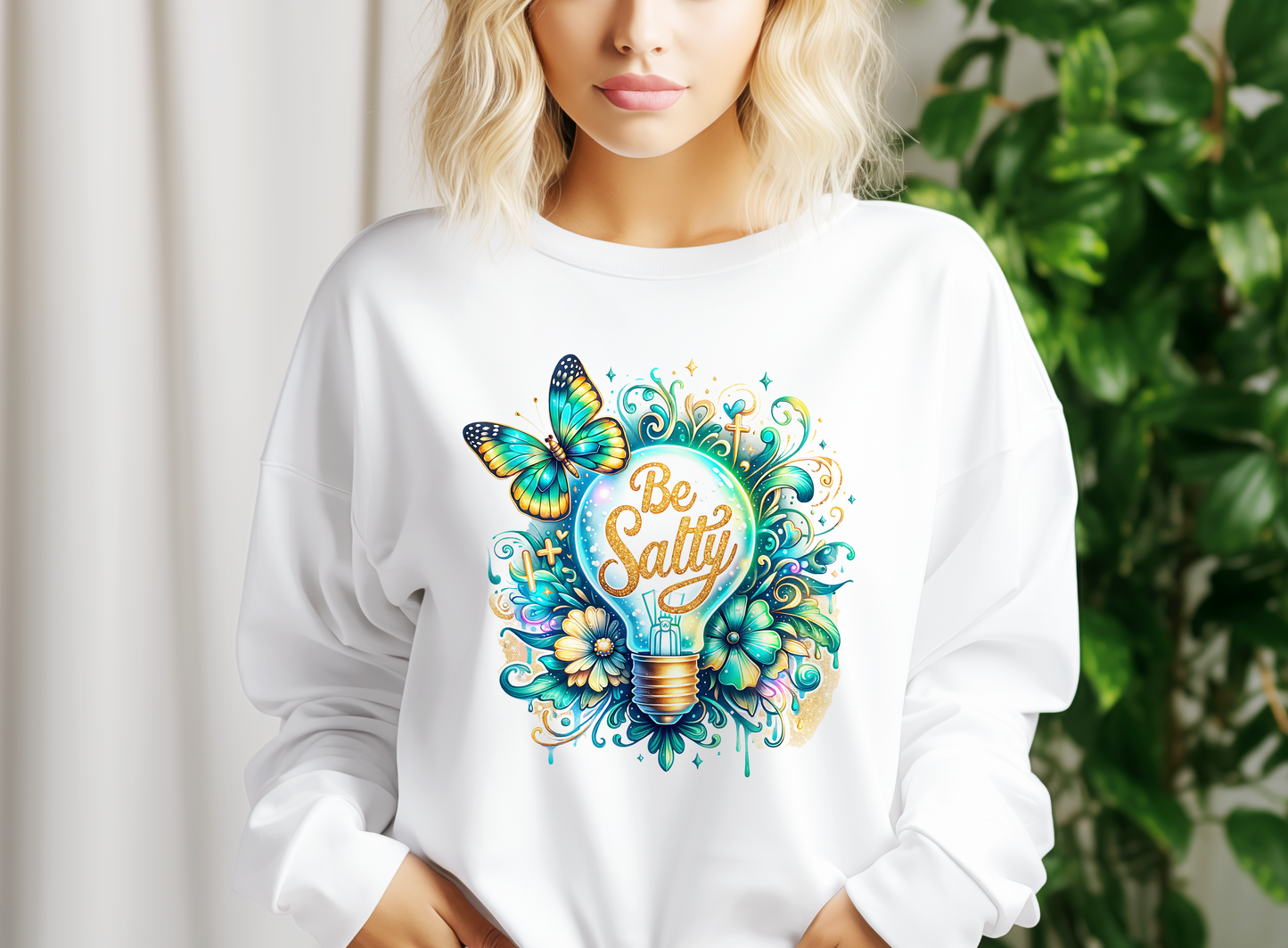 a woman wearing a white sweatshirt with the words be salty on it