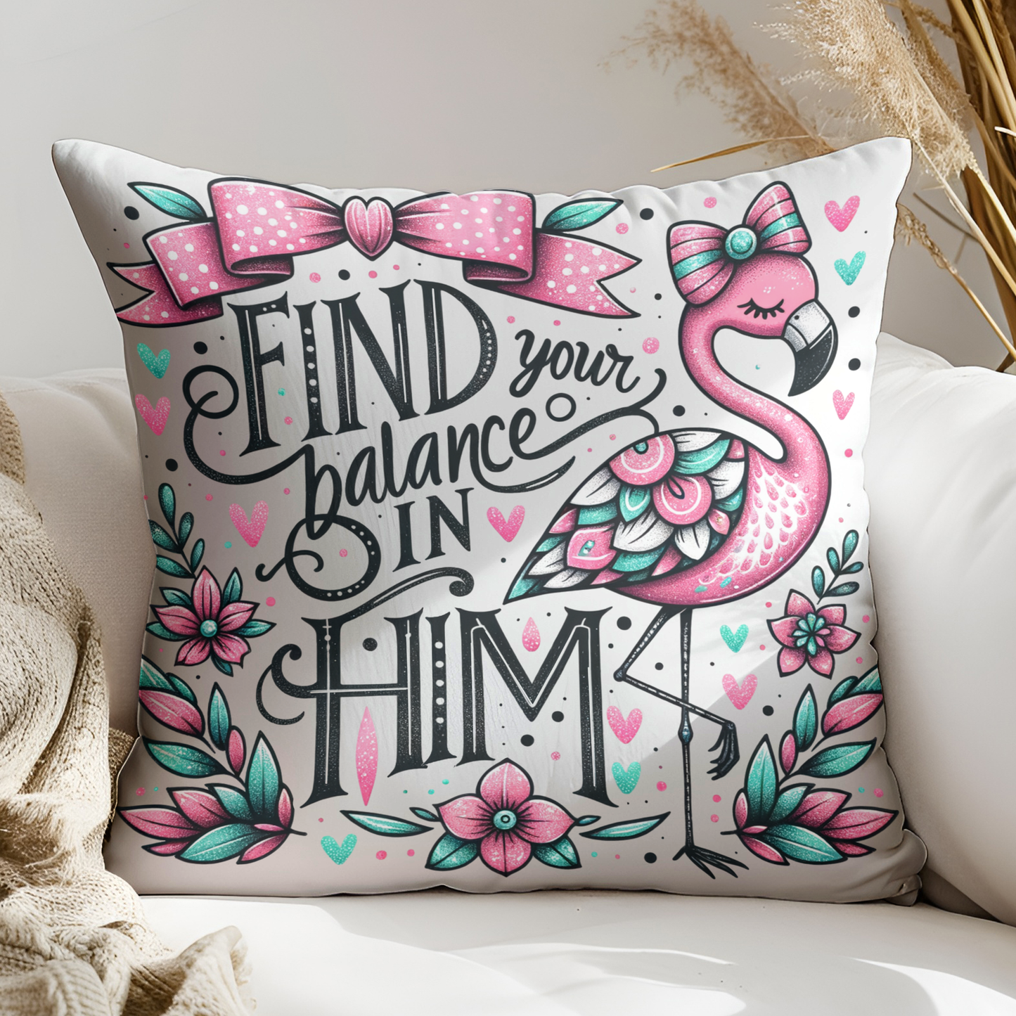 A decorative throw pillow with a pink flamingo and floral designs, along with the text "Find your balance in Him" and a bow.