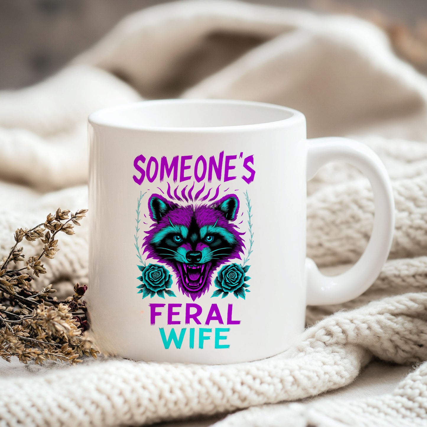 a white coffee mug sitting on top of a white blanket