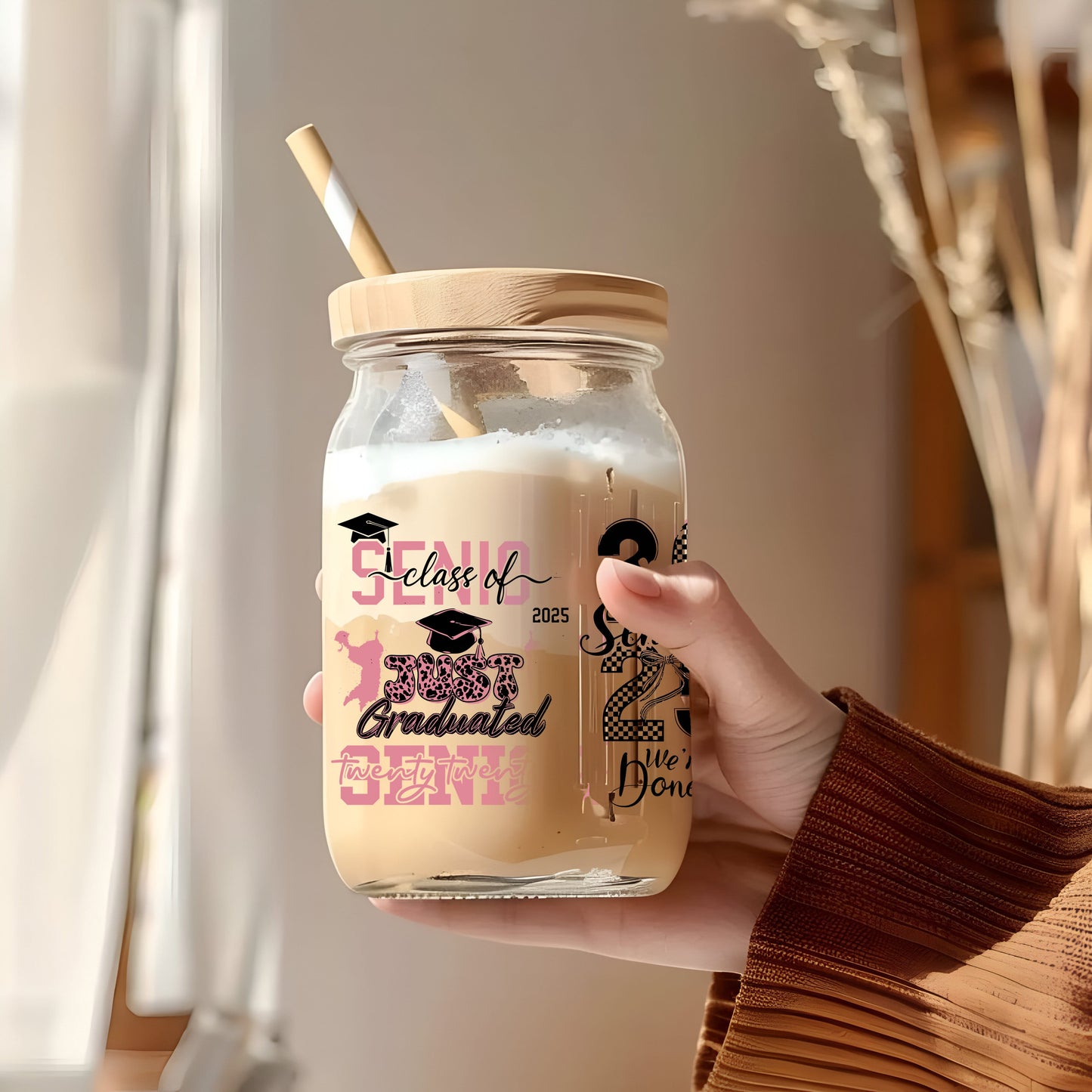 a person holding a glass jar with a straw in it