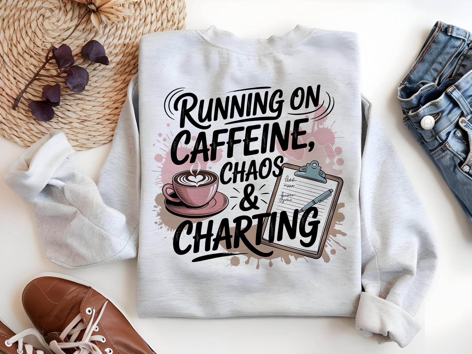 a white sweatshirt with a humorous text design that reads "Running on Caffeine, Chaos & Charting". The design includes a coffee cup and a clipboard with a list, suggesting a playful take on the idea of being constantly busy and needing a caffeine boost.