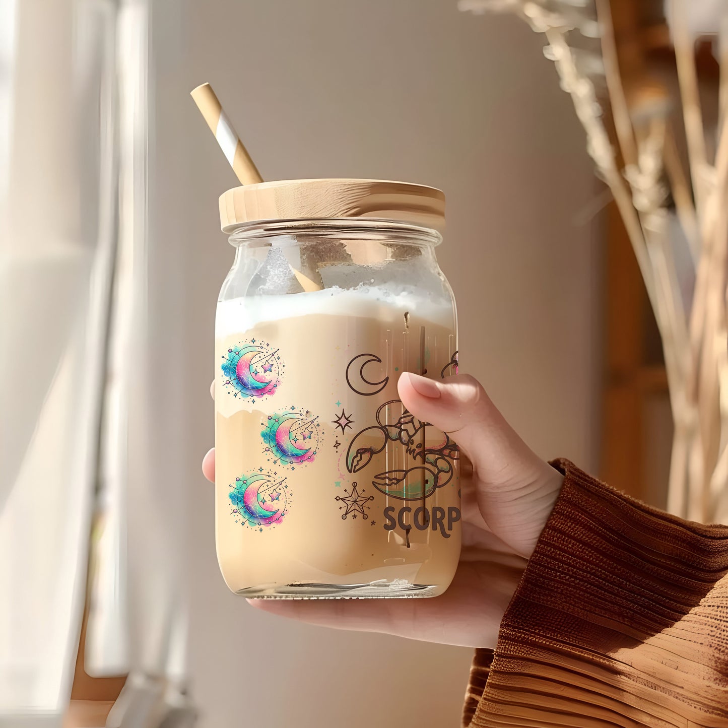 a person holding a jar with a straw in it
