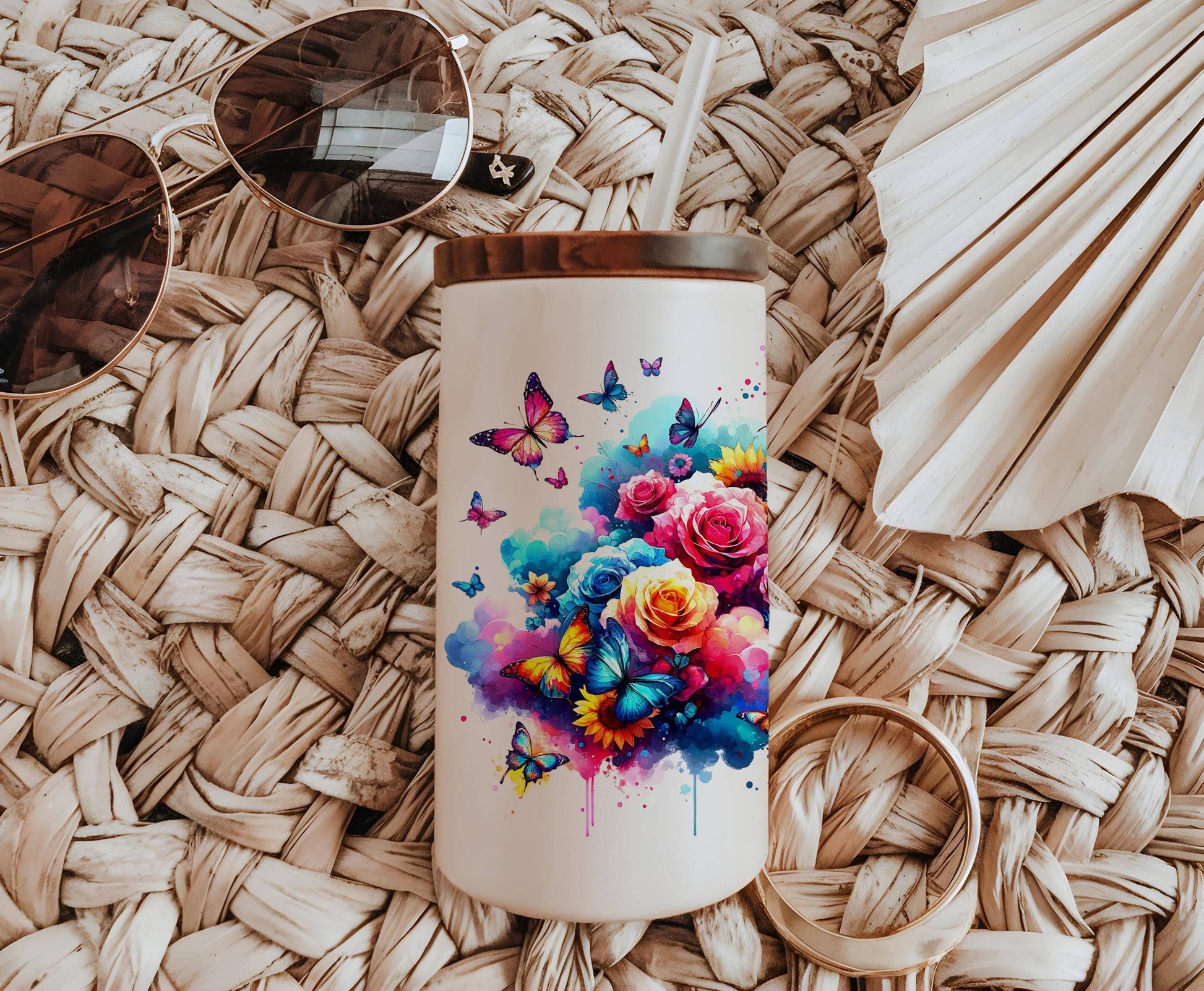 a white coffee mug with a painting of flowers and butterflies on it
