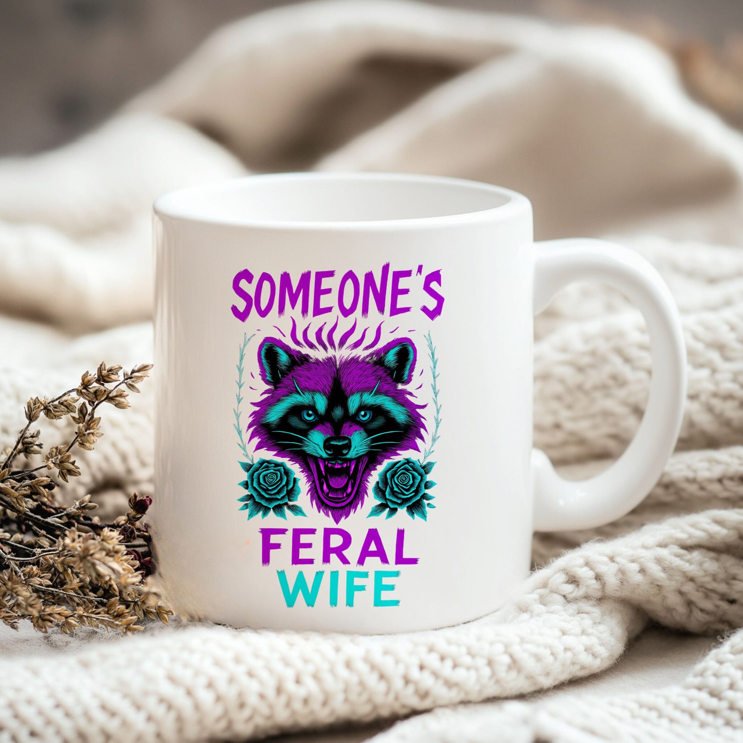 a white coffee mug sitting on top of a white blanket