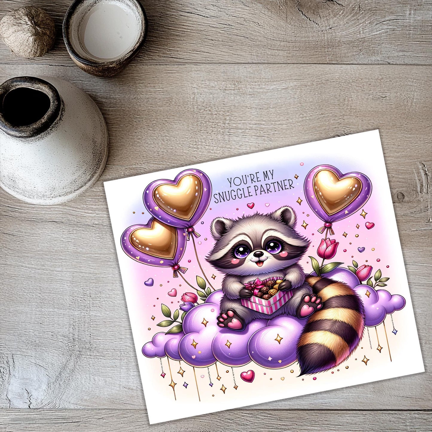 a card with a raccoon holding balloons